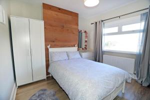 a bedroom with a bed and a large window at Lisburn Townhouse in Lisburn