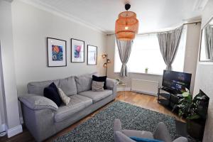 a living room with a couch and a tv at Lisburn Townhouse in Lisburn