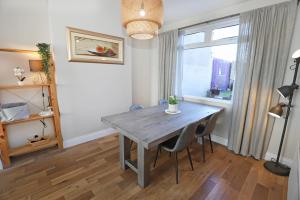 a dining room with a wooden table and a window at Lisburn Townhouse in Lisburn +11 photos