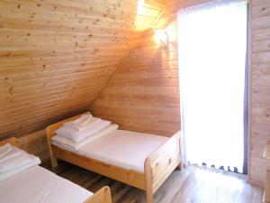 a room with two beds in a wooden cabin at Terraced House in Rewal near Baltic Sea Beach in Rewal