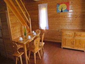 a dining room with a table and chairs in a log cabin at Terraced House in Rewal near Baltic Sea Beach in Rewal +23 photos