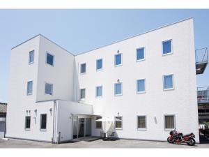 a white building with a motorcycle parked in front of it at Hotel M&K Ishinomaki - Vacation STAY 54465v in Ishinomaki