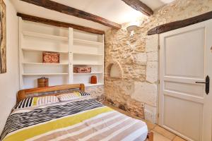 a bedroom with a bed and a stone wall at Raisin et Toile - French American Retreat in La Rochebeaucourt-et-Argentine +143 photos