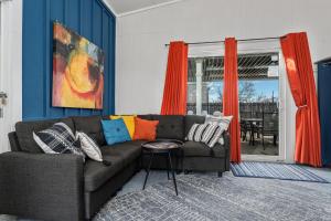 a living room with a couch and orange curtains at Cosmopolitan- Hot Tub Heated Pool & Fire Pit in Fredericksburg