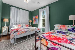 a bedroom with two beds and green walls at Cosmopolitan- Hot Tub Heated Pool & Fire Pit in Fredericksburg