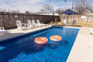 a swimming pool with two inflatable chairs and an umbrella at Cosmopolitan- Hot Tub Heated Pool & Fire Pit in Fredericksburg +75 photos