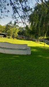 a park with a bench in the grass at Emasimini Cottages in Midrand