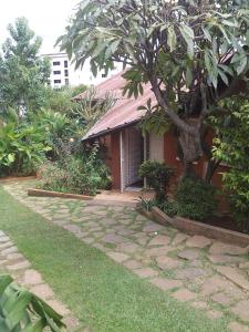 a house with a stone path in front of it at B&B Au Triporteur in Antananarivo
