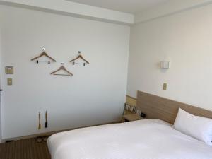 una camera da letto con letto e appendiabiti a muro di Smile Hotel Shirakawa - Vacation STAY 54756v a Nishigo