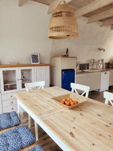 a kitchen with a wooden table with a bowl of oranges on it at Ferienhaus Rosa in Dorum Neufeld