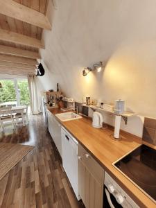 a large kitchen with wooden floors and a counter top at Ferienhaus ROSA mit Sauna in Dorum-Neufeld +23 photos