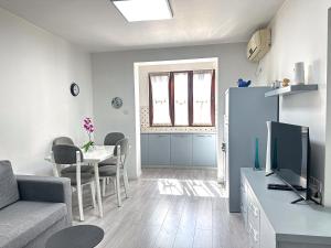 a living room with a couch and a tv and a table at City Center 2BR Apartment in Tirana