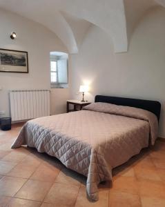 a bedroom with a bed and a table with a lamp at Ninì - Casa torre nel borgo in Pontremoli