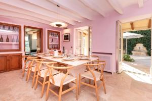 a dining room with a white table and chairs at Casa de Piedra ubicada en el exclusivo wine village de Viladellops, te ofrece una experiencia única, donde el lujo y la tradición se fusionan en un entorno natural privilegiado in Viladellops