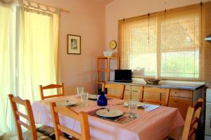 a dining room table with chairs and a table with a tableablish at Blue Lagoon Villa in Poros