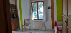 a room with a window and two chairs and a table at Gîtes des Cèdres in Crestet