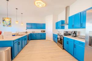 a blue kitchen with white walls and blue cabinets at Surfside Sanctuary in South Padre Island