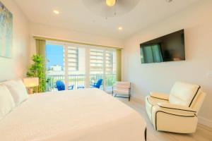 a bedroom with a large bed and two chairs at Surfside Sanctuary in South Padre Island