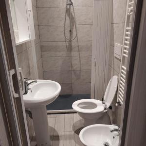 Un baño con lavabo, inodoro y ducha. en Doberdó, en Milán
