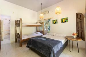 a bedroom with two bunk beds and a table at Hostal Casa del Rio in Guachaca +16 photos