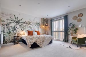 una camera da letto con un grande letto e carta da parati tropicale di Cambridge - hot tub, sauna, parking, pool table a Trumpington