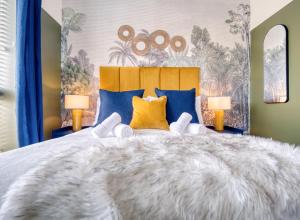 una camera da letto con un letto grande con cuscini blu e gialli di Cambridge - hot tub, sauna, parking, pool table a Trumpington Altre 49 foto