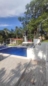 a swimming pool with a picnic table and a table at Hostal Casa del Rio in Guachaca