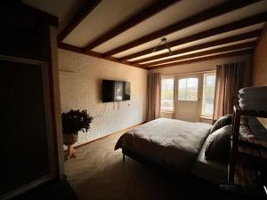 a bedroom with a bed and a tv on the wall at De Cirkel Brucht-Hardenberg in Brucht