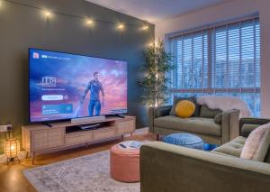 un soggiorno con una grande TV a schermo piatto di Cambridge - hot tub, sauna, parking, pool table a Trumpington