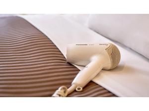 東京にあるThe OneFive Tokyo Kameido - Vacation STAY 64621vのベッドの上にタンヘアドライヤーが備わります。