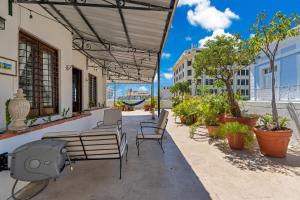 un patio con sillas, mesa y sillas en Spacious Apartment in the Heart of San Juan, en San Juan