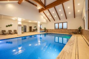 a pool in a house with a large ceiling at Kaniówka Ski Resort- relaks w górach z basenem, sauną i jacuzzi in Białka Tatrzanska