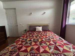 a bed in a room with a quilt on it at Villa Deep Blue Poerava with pool in Punaauia +19 photos