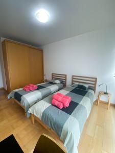 two beds in a room with red pillows on them at Amazing Views in Machico in Machico