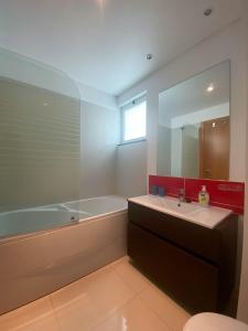 a bathroom with a tub and a sink and a mirror at Amazing Views in Machico in Machico