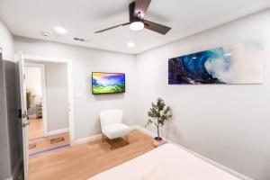 a white room with a ceiling fan and a chair at Exotic home Cumberland street by sdstay in San Diego