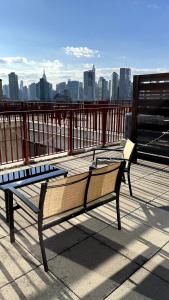two benches sitting on a balcony with a view of a city at 5 mins to Midtown Central New Luxury Corner 2b2b Apt with Amazing City View in Long Island City