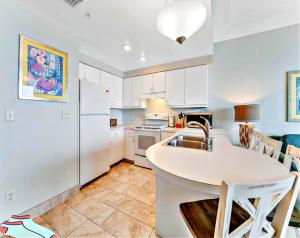 a kitchen with a sink and a white refrigerator at Highly Desired 6th Floor 1 BR Oceanfront - There Is Only One Ocean Walk Resort 606 in Daytona Beach