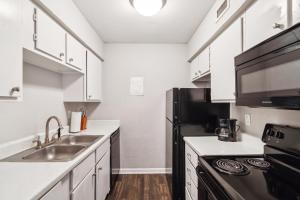 アーリントンにあるStratton 205-v I Spacious 1 Bed 1 Bathの白いキャビネットと黒い冷蔵庫のあるキッチン