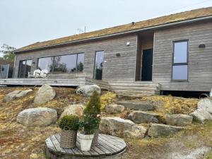 a house with two potted plants in front of it at Flott hytte på Bersagel nær sjø in Sandnes
