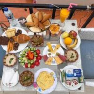 uma mesa com muitos pratos de comida em Golden Pyramids View Inn em Cairo