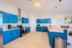 a blue kitchen with white walls and blue cabinets at Sandbar Serenade in South Padre Island