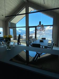 una sala da pranzo con tavolo e sedie e una grande finestra di The Panoramic Chalet a Stranda