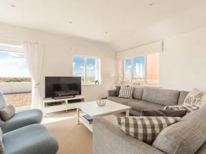 a living room with a couch and a tv at Southern Bell in South Hayling