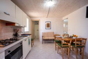 Una cocina y un comedor con mesa y sillas. en Appartamento Depandance 1 Villa Ada Punta Prosciutto, en Punta Prosciutto 10 fotos más