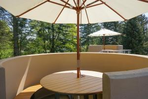 a wooden table with an umbrella on aolicy at slube am Krakower See in Krakow am See
