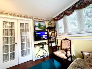 a living room with a chair and a television at Barker House 1# Suite-heart of oldtown in Niagara on the Lake +14 photos
