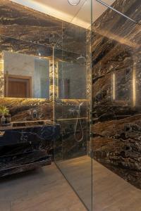 a bathroom with a glass shower with a mirror at Natural Stone Villas Kefalonia in Trapezaki