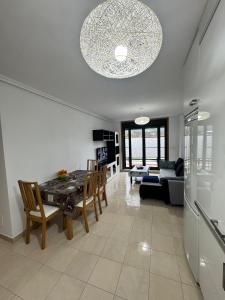 Una sala de estar con una mesa y sillas y un sofá. en Apartamento Herosa 2 Spa, en San Miguel de Reinante