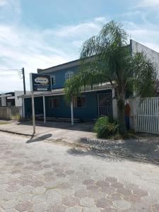 a blue building with a palm tree in front of it at Residencial Primavera in Pontal do Paraná +52 photos